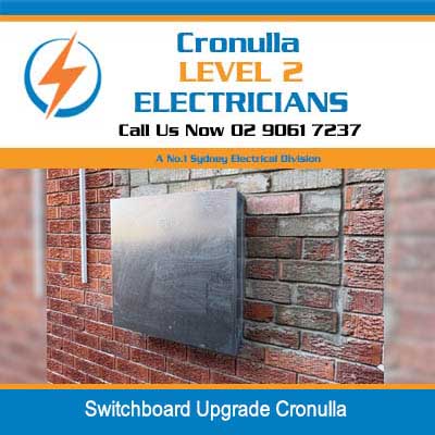 Gray electrical switchboard upgrade mounted on red brick wall exterior in Cronulla